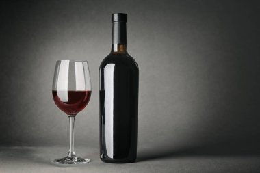 -Bir şişe şarap ve gri arka plan üzerinde cam