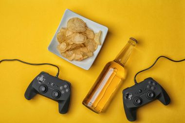 Video oyun kumandaları, bira ve aperatif renk arka plan üzerinde kompozisyonu