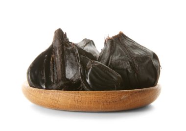 Beyaz arka planda siyah sarımsak (Allium sativum) ile plaka