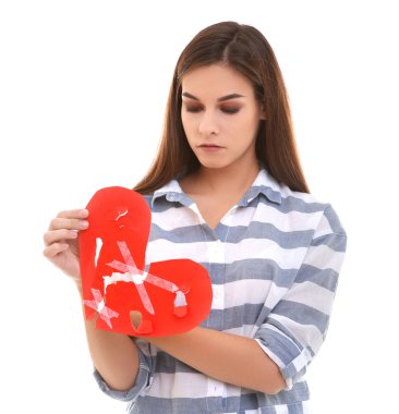 Mutsuz kadın kalçası kağıt kalp üzerinde beyaz arka plan ile. Ayrılık kavramı