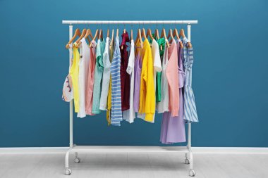 Renk duvarının yakınında farklı kıyafet ile raf