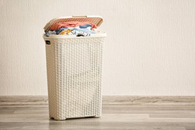 Işık duvarının yakınında giysileri ile çamaşır sepeti