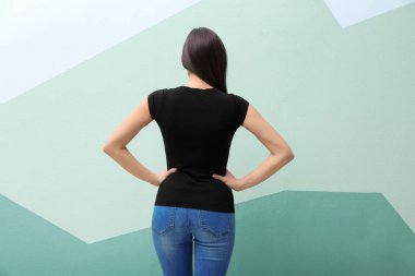 Renk arka plan üzerinde siyah t-shirt bir genç kadın. Mockup tasarım için