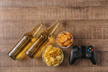 Video oyun denetleyicisi, bira ve aperatif ahşap arka plan üzerinde kompozisyonu