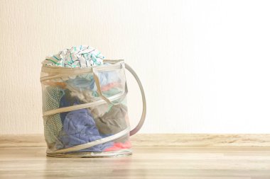 Işık duvarının yakınında giysileri ile çamaşır sepeti