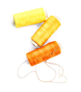 Dikiş ipliği ve beyaz arka plan üzerinde iğne makaralar