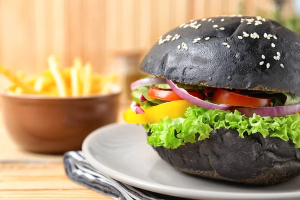 Teller Mit Leckerem Schwarzen Burger Auf Dem Tisch Nahaufnahme — Stockfoto