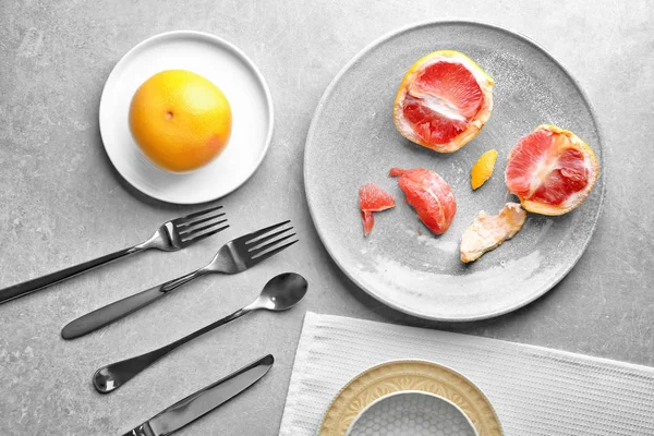 灰色背景下的柚子和餐具陶瓷板 — 图库照片