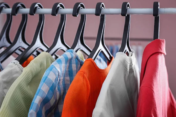 Καθαρά Ρούχα Που Κρέμεται Στο Ράφι Στο Πλυντήριο Κοντινό Πλάνο — Φωτογραφία Αρχείου