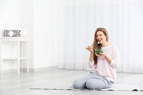 Mladá krásná žena jíst čerstvý salát doma — Stock fotografie