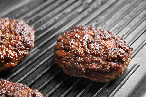 Burger patty on grill surface, closeup