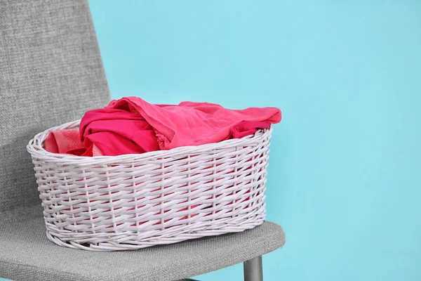 Vit Tvättkorg Med Kläderna Stolen Mot Färg Bakgrunden — Stockfoto