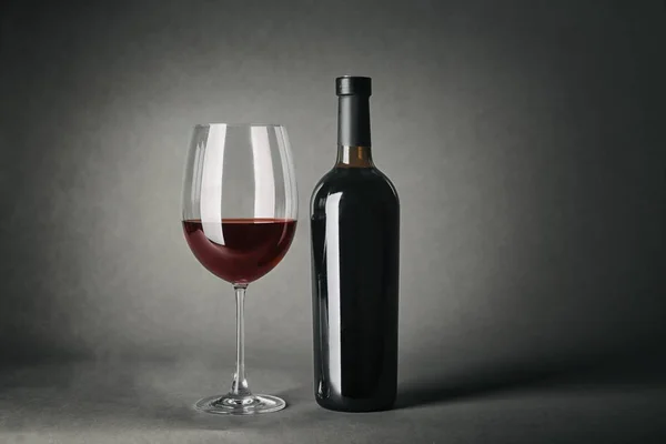 ワインと灰色の背景にガラスのボトル — ストック写真