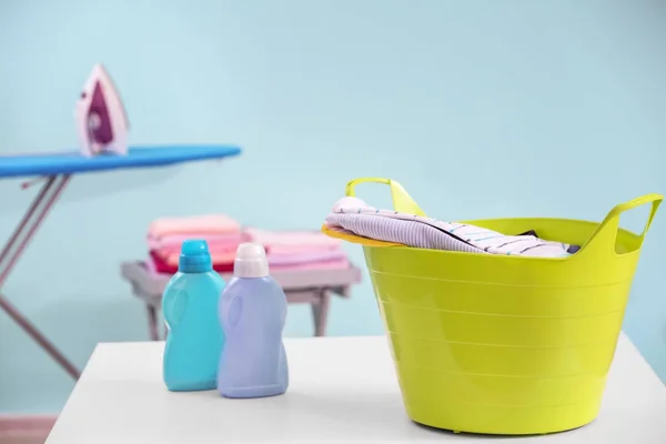 Plastic laundry basket with clothes indoors