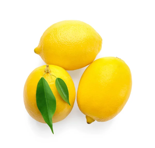Färska mogna citroner med blad på vit bakgrund — Stockfoto