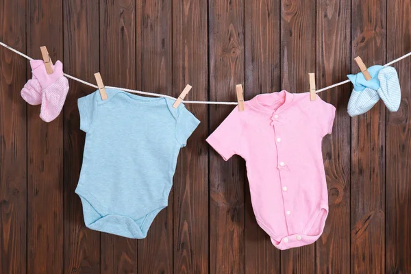 Barnkläder Tvätt Linje Mot Trä Bakgrund — Stockfoto