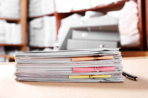 Стопка старых бумажных документов на столе в архиве
