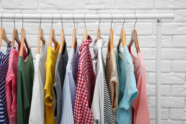 Rek Met Verschillende Kleding Buurt Van Bakstenen Muur — Stockfoto