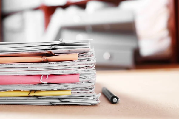 Stack of old paper documents on table in archive