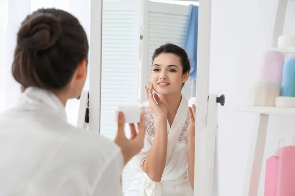 Attrayant Jeune Femme Appliquant Crème Visage Dans Salle Bain — Photo