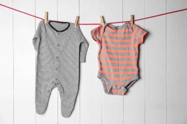 Ahşap arka plan karşı Çamaşırhane satırındaki çocuk giyim