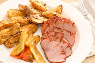 Dilimlenmiş bal pişmiş jambon ve sebze masada, closeup ile plaka
