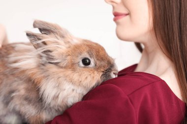 Beautiful young woman with pet rabbit on white background, closeup clipart