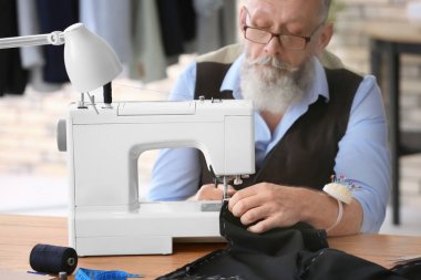 Atelier dikiş makinesi üzerinde çalışan üst düzey terzi