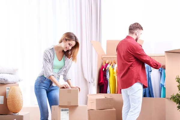 Young couple packing wardrobe boxes on moving day — Stock Photo, Image