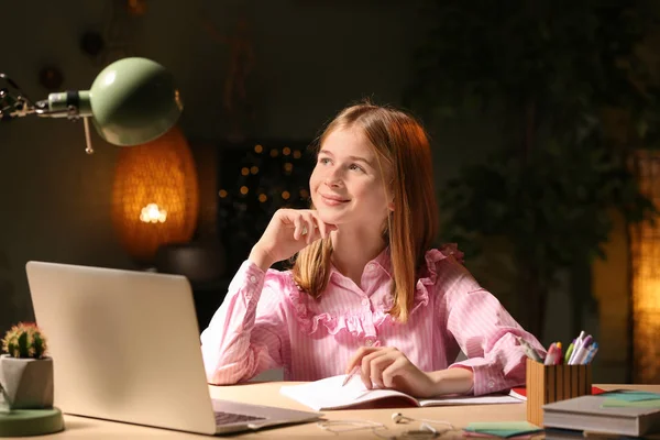 Tienermeisje huiswerk aan tafel in de avond — Stockfoto