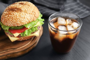 Kadeh tabloda lezzetli hamburger ile soğuk kola