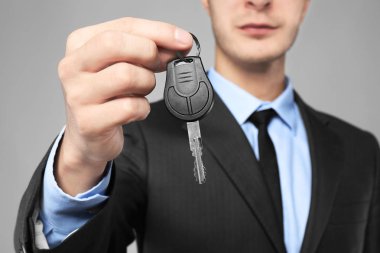 Araba satıcısı ile gri arka plan, closeup üzerinde anahtar