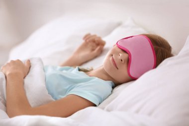 Sevimli kız evde beyaz yastık üzerinde uyuyor