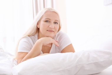 Üst düzey kadın evde beyaz yastık üzerinde yalan