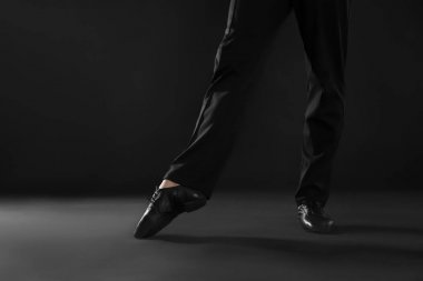 Genç adam koyu Studio dans edenlerin bacaklarını