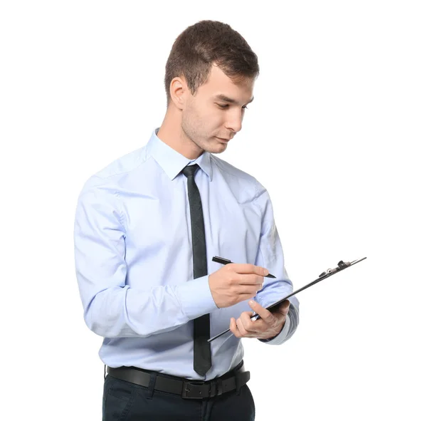 Handsome car salesman writing on clipboard against white background — Stock Photo, Image