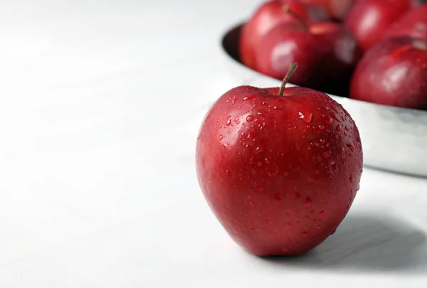 Ripe red apple on white table, selective focus