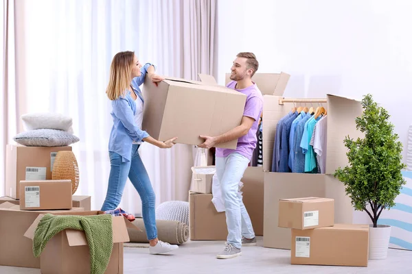 Jong koppel met kledingkast vakken over het verplaatsen van de dag — Stockfoto