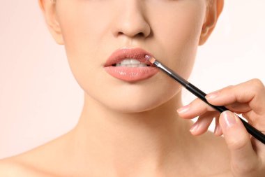 Açık renkli kadının yüzünde makyaj uygulayarak profesyonel visage sanatçı