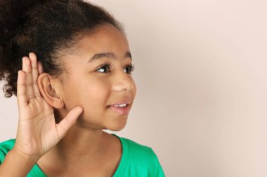 Küçük Afrikalı-Amerikalı kız ile açık renkli işitme sorunu