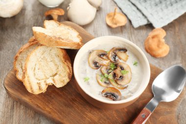 Ahşap tahta üzerinde mantar çorbası ile kase