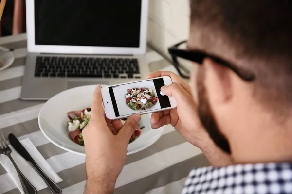 Young blogger taking photo of food with mobile phone in cafe — Stock Photo, Image