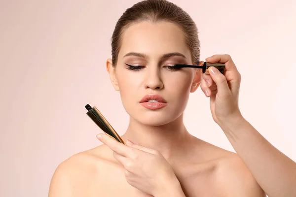 Professionell visage konstnären tillämpa makeup på kvinnans ansikte på ljus bakgrund — Stockfoto