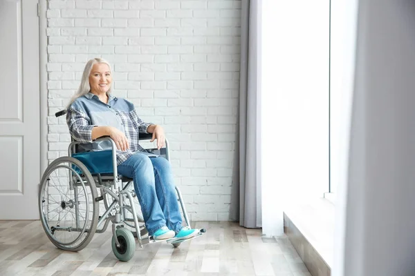 Reife Frau im Rollstuhl drinnen — Stockfoto