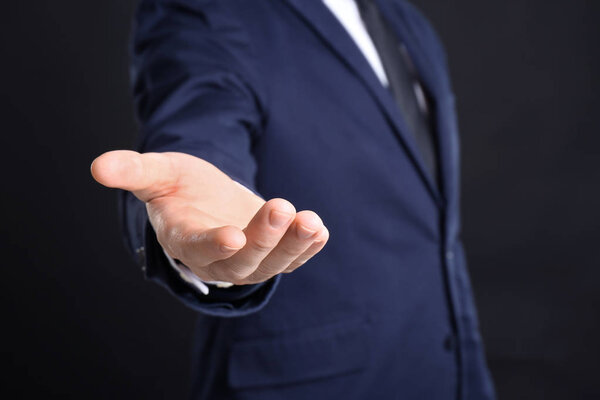 Businessman demanding bribe on black background