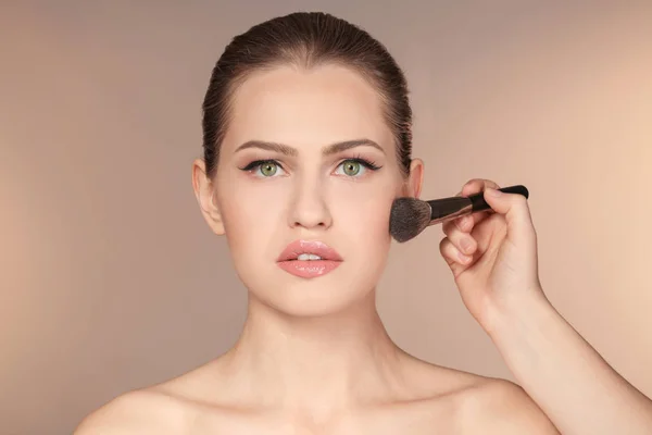 Artista visage professionale applicare il trucco sul viso della donna su sfondo di colore — Foto Stock