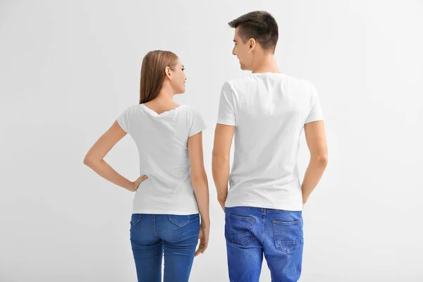 Молодая женщина и мужчина в футболках на белом фоне. Макет для дизайна — стоковое фото