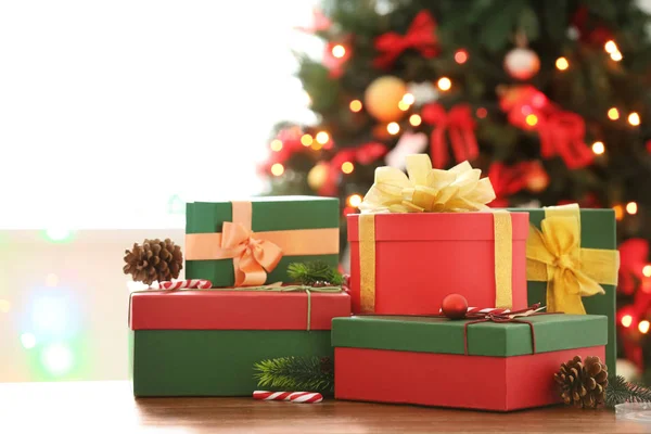 Wrapped gifts on table against blurred Christmas tree. Boxing day — Stock Photo, Image