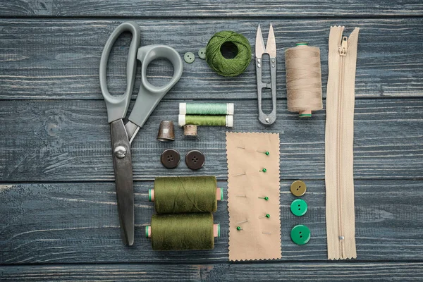 Fios coloridos e acessórios de costura em fundo de madeira — Fotografia de Stock
