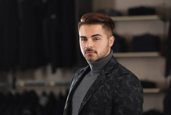 Hombre joven en ropa elegante en la tienda de ropa masculina —  Fotos de Stock